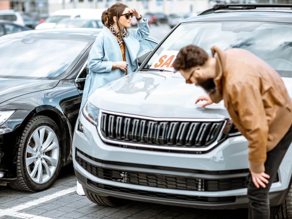 Inspecting a used car before purchase to evaluate its condition.