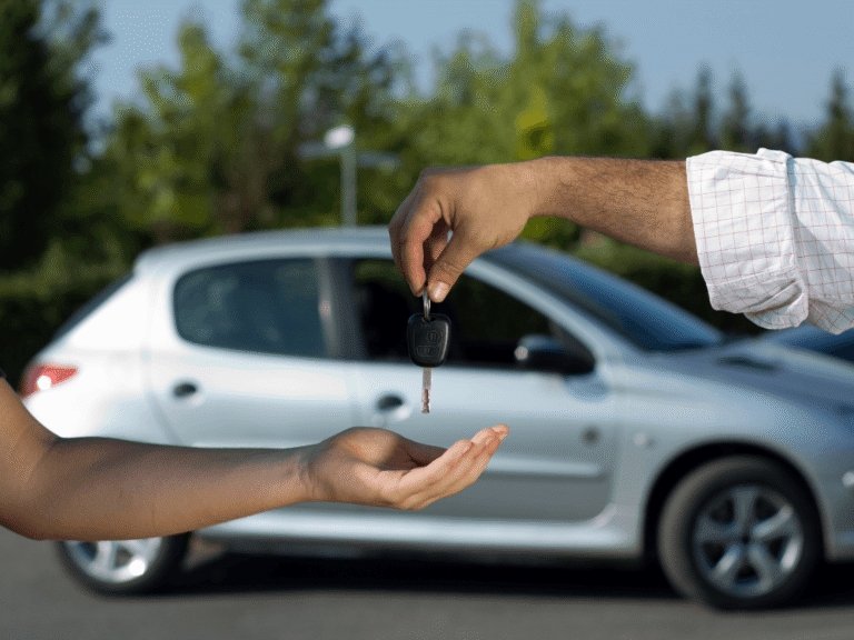A person handing car keys to another, symbolising the process of buying a used car.